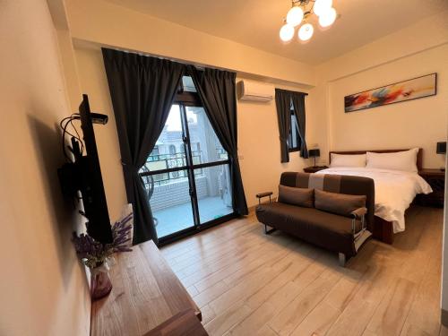a bedroom with a bed and a couch and a window at 玉里香椿芽民宿 in Yuli