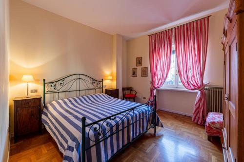 una camera da letto con un letto e una finestra con tende rosse di Residenza Corsocangrande25 a Lazise