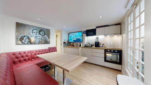 un salon avec un canapé rouge et une table en bois dans l'établissement Casa Volpe, à Paris