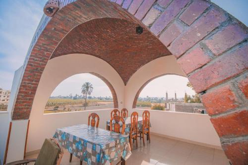 a dining room with a table and chairs and a brick wall at Tasneem Palace in Luxor
