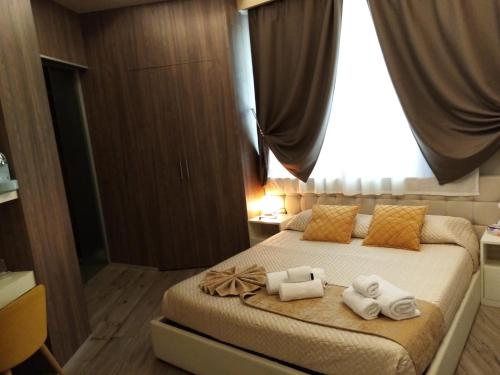 um quarto com uma cama com toalhas em Th Luxury em Giardini Naxos