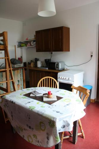une cuisine avec une table recouverte d'une nappe dans l'établissement petit studio, bien équipé, à la campagne, à Marcoux