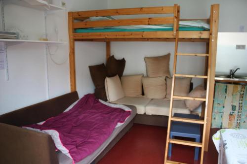 - un lit superposé et un canapé dans une chambre dans l'établissement petit studio, bien équipé, à la campagne, à Marcoux