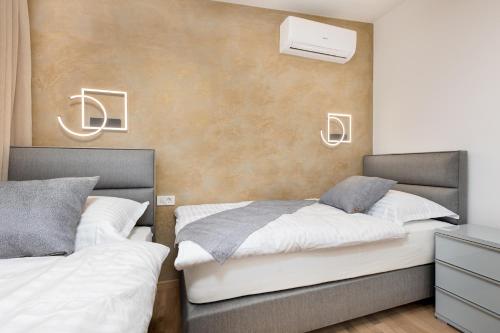 two beds sitting next to each other in a bedroom at Apartment Mužini Malinska in Malinska
