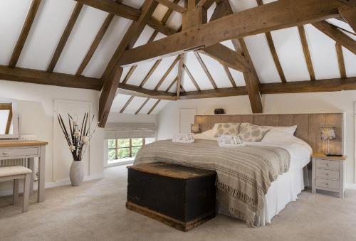 ein Schlafzimmer mit einem großen Bett in einem Zimmer mit Holzdecken in der Unterkunft Broad Meadows Farmhouse 12 Guests in Bayton