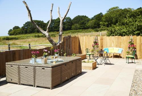 a patio with a table with flowers on it at Bokes Barn in Hawkhurst
