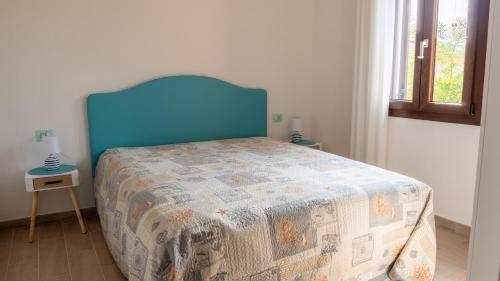 a bed with a blue head board in a bedroom at residence lu soli budoni affitti in Budoni