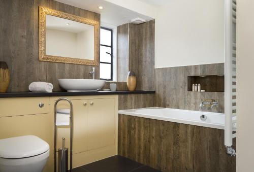 a bathroom with a tub and a toilet and a sink at Broad Meadows Farmhouse 8 Guests in Bayton