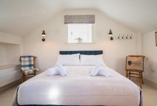 a bedroom with a large white bed with two pillows at Bryn Mawr in Eglwys-Fâch