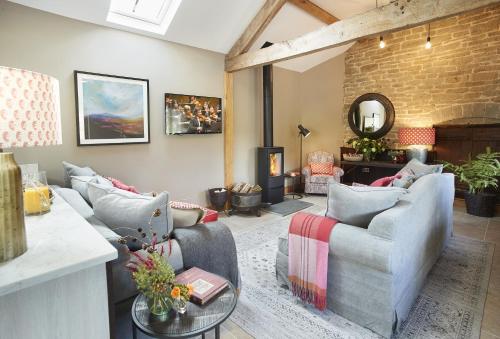 a living room with two couches and a fireplace at The Cart Shed Shropshire in Downton