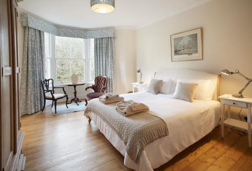 Un dormitorio con una cama, un escritorio y una mesa. en Rosevean House, en St. Agnes