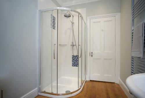 a shower with a glass door in a bathroom at Rosevean House in St. Agnes