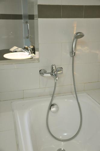a shower in a bathroom with a sink and a tub at LAMORA Sagan Yogyakarta - formerly H Boutique Yogyakarta in Yogyakarta