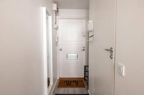 un corridoio con una porta bianca con un cartello di 2ndhomes Modern Studio with Central Location a Helsinki
