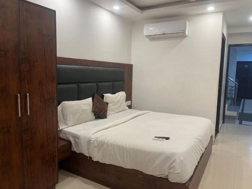 a bedroom with a large bed with a wooden cabinet at THE Flight path Unit By Urban Luxury Delhi Airport in New Delhi