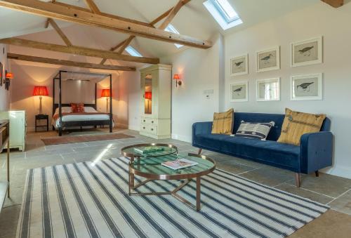 a living room with a blue couch and a table at Bodney Lodge in Bodney