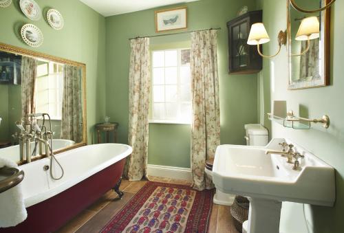 a bathroom with a tub and a sink and a window at The Green in Coneysthorpe