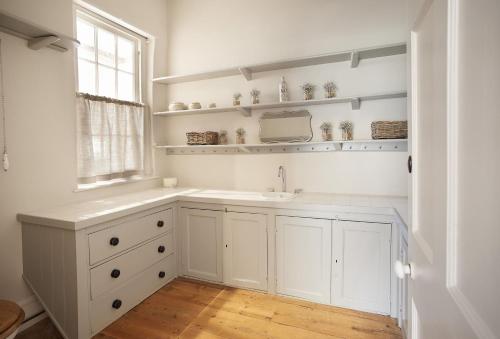 uma casa de banho branca com um lavatório e uma janela em Walesby House em Walesby