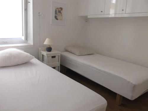 deux lits dans une chambre blanche avec une fenêtre dans l'établissement 3 Piéces climatisé 4 personnes Nice tout confort plein centre, à Nice
