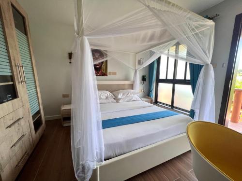 um quarto com uma cama de dossel branca em Zebi Ecolodge em Hoima