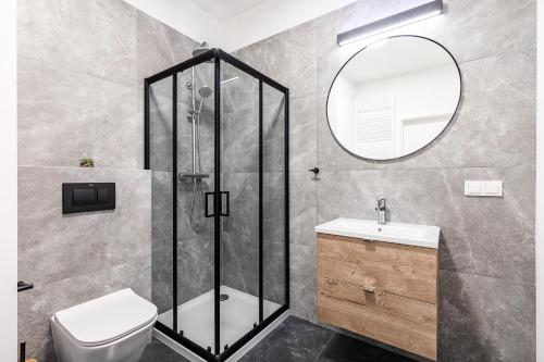 a bathroom with a shower and a toilet and a sink at Platinum Apartments in Warsaw
