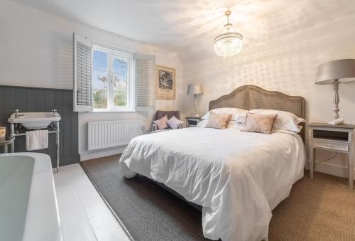 a bedroom with a bed and a sink and a tub at 1 Church Cottages 