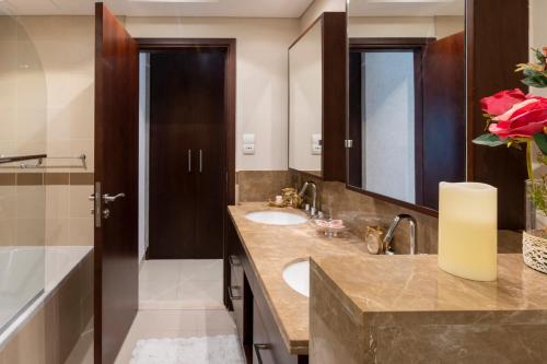 een badkamer met een wastafel en een grote spiegel bij Downtown Dubai, Luxury 2 Bed 2 Bath Apartment - Pool, Gym, AirCon, Parking - Views of The Dubai Fountain & Burj Khalifa in Dubai