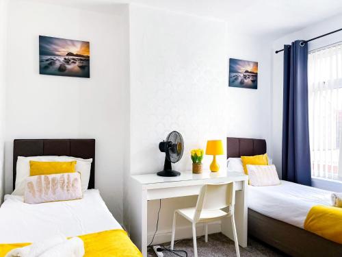 a bedroom with two beds and a desk in it at Beautiful 2 Bedroom House - Free Parking - LT House in Leicester