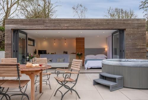 a backyard patio with a hot tub and a bedroom at The Garden Room in Westmeston
