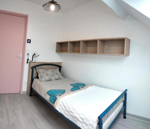 ein kleines Schlafzimmer mit einem Bett in einem Zimmer in der Unterkunft Les Coquelicots in Cormaranche-en-Bugey