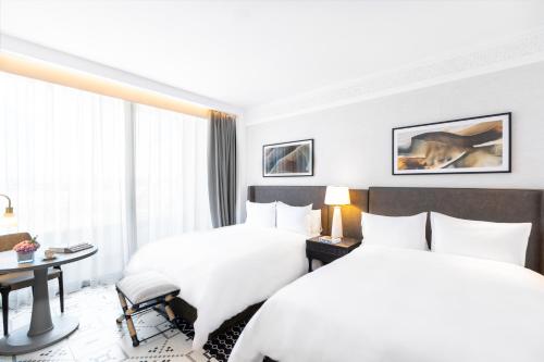 a hotel room with two beds and a desk at Fairmont La Marina Rabat Sale Hotel in Rabat