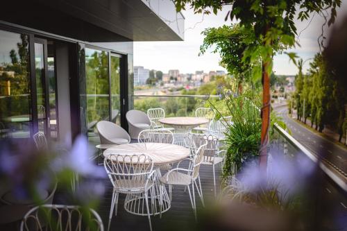 un grupo de mesas y sillas en un balcón en My Story Gdynia Hotel en Gdynia