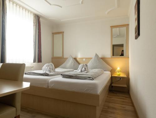 ein Hotelzimmer mit 2 Betten und einem Spiegel in der Unterkunft Gasthaus Traube, Ludwigshafen, Bodensee, Seenah gelegen in Bodman-Ludwigshafen