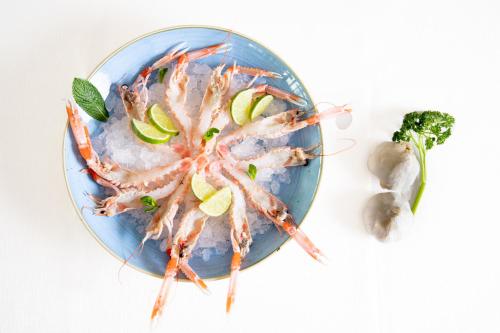a plate of food with a shrimp and vegetables at Casa Merano Residence & Restaurant Bibione Centro in Bibione