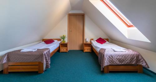 a attic room with two beds and a window at Ledan in Chłopy