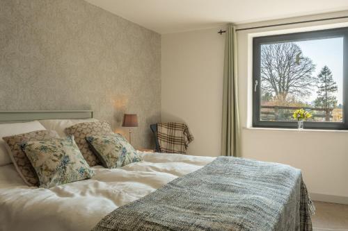 a bedroom with a large bed with a window at Linden Barn in Orton