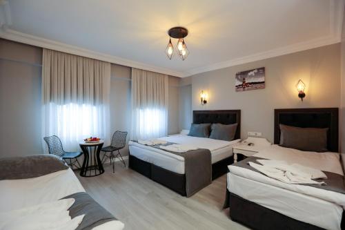 Habitación de hotel con 2 camas y mesa en Grand Inova Hotel en Estambul