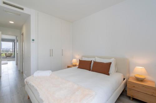 - une chambre blanche avec un grand lit blanc et deux lampes dans l'établissement Oceana Views, Cancelada, à Estepona