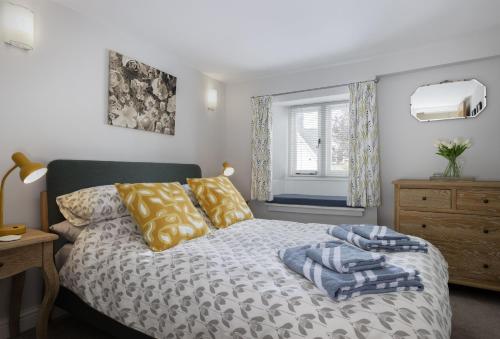 a bedroom with a bed and a window at Rock Cottage in Minchinhampton