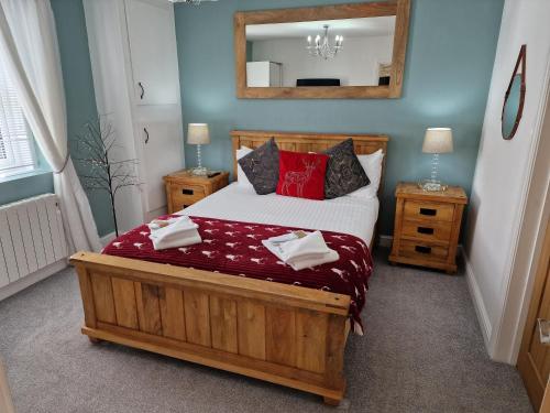 1 dormitorio con cama con almohadas rojas y espejo en Stunning 1-Bed Cottage near Carlisle with Hot tub, en Carlisle