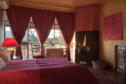 a bedroom with a bed with a red bedspread at L'Isola Di Rosa - Relais & Hotel di Charme in Cerveteri