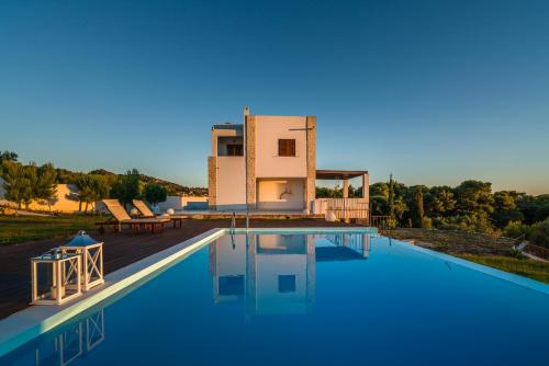 a villa with a swimming pool in front of a house at Kalas SeaView Residence, a Serene Sanctuary, By ThinkVilla in Zakynthos