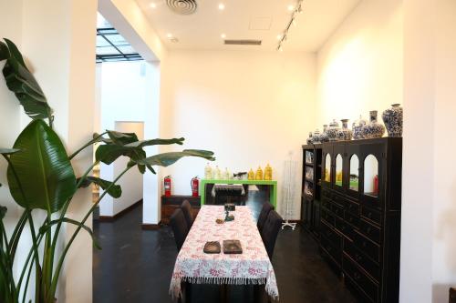 a dining room with a table and a plant at Hotel Cote Cour Deductive Beijing - Quadrangle close to Tiananmen Square & Forbidden City & Nanluoguxiang, Walk to Wangfujing, English speaking, Free WiFi, Free Laundry, Free Wonton & Noodles with Tour ticket service, Free selfies with ancient costume in Beijing