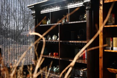a shelf with various items on it in a room at Hotel Cote Cour Deductive Beijing - Quadrangle close to Tiananmen Square & Forbidden City & Nanluoguxiang, Walk to Wangfujing, English speaking, Free WiFi, Free Laundry, Free Wonton & Noodles with Tour ticket service, Free selfies with ancient costume in Beijing
