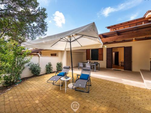 patio con sedie e ombrellone su casa di House Adele - Cala Sinzias a Villasimius