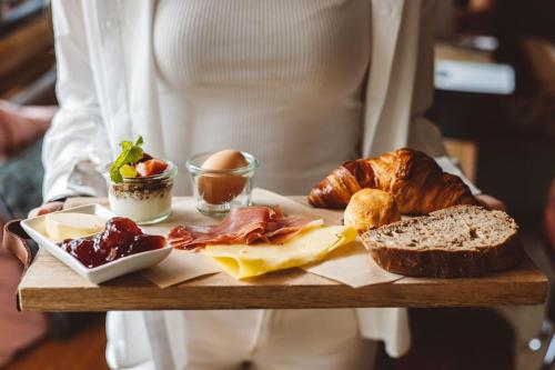 una persona che tiene in mano un vassoio di diversi tipi di alimenti di Hotel Emma a Rotterdam