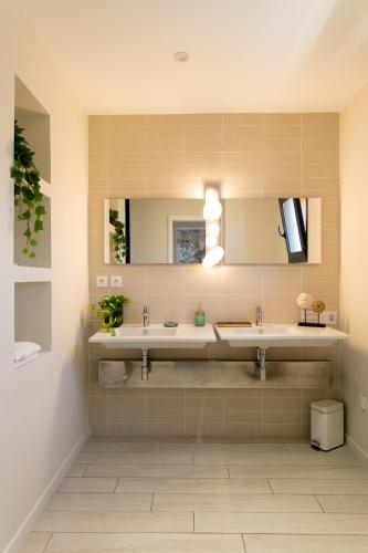 a bathroom with two sinks and a mirror at Villas les Capucines in Sète