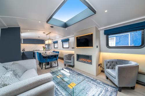 JOIVY Elegant houseboat near Canary Wharf في لندن: غرفة معيشة وغرفة طعام في عربة ترفيهية