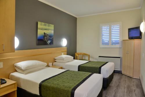 a hotel room with two beds and a television at Road Lodge Southgate in Southgate