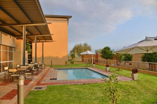a backyard with a pool and a table and chairs at Road Lodge Southgate in Southgate